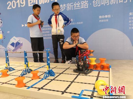 图为兰州市城关区华侨实验学校五年级学生刘沐钊和团队成员展示VEX机器人。 杜萍 摄